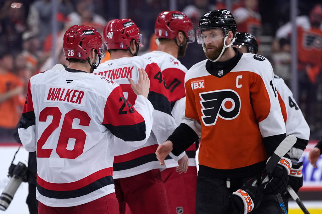 Philadelphia Flyers' Sean Couturier, right, and Carolina Hurricanes' Sean Walker meet after Game 4 in a second-round NHL hockey Stanley Cup playoff series Saturday, May 9, 2026, in Philadelphia. (AP Photo/Matt Slocum)