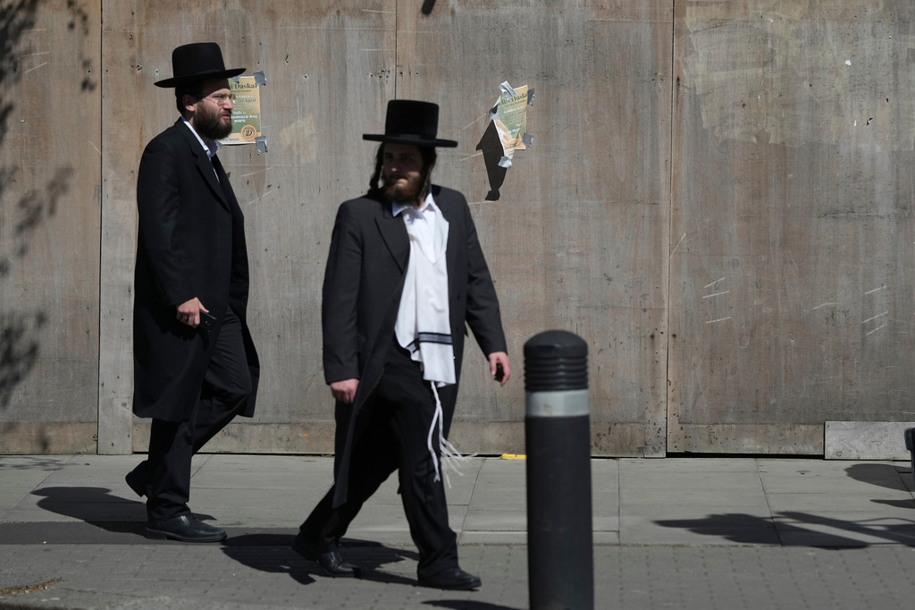 Two men walk in London, Thursday, April 30, 2026, near the scene where two people were recently stabbed in the Golders Green neighbourhood, that has a large Jewish community. (AP Photo/Alastair Grant)
