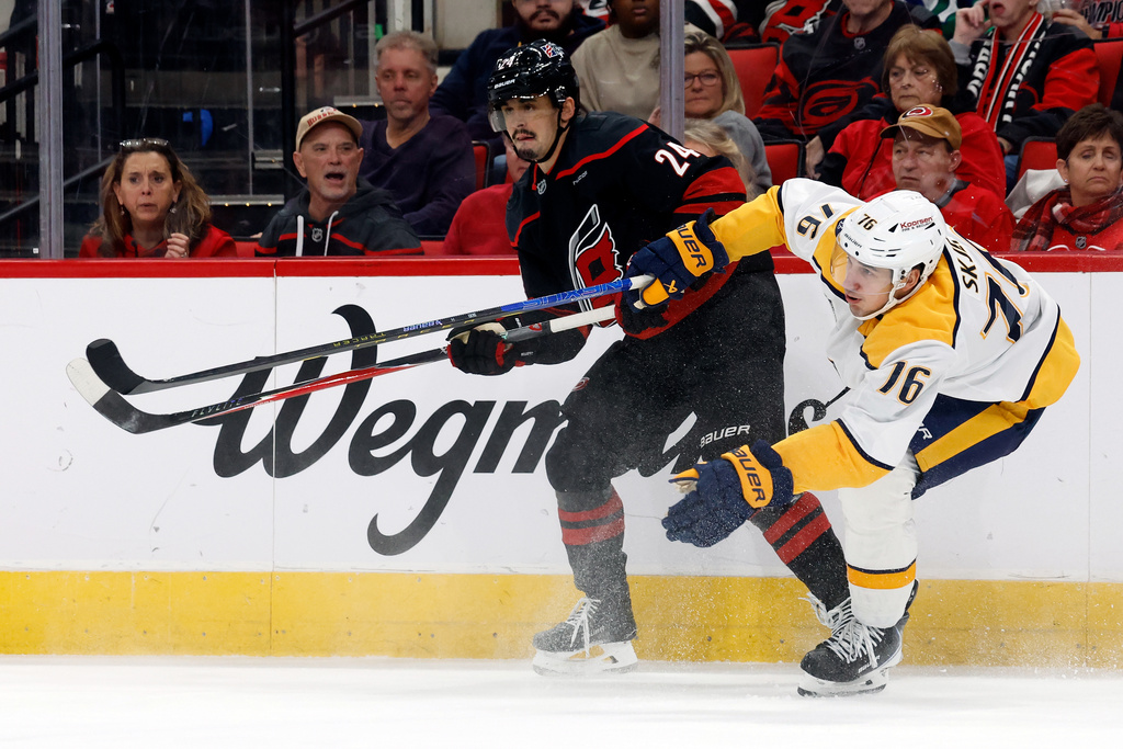 Carolina Hurricanes' Seth Jarvis (24) battles with Nashville Predators' Brady Skjei (76) during the second period of an NHL hockey game in Raleigh, N.C., Saturday, Dec. 6, 2025. (AP Photo/Karl DeBlaker)