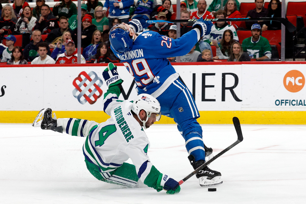 Carolina Hurricanes' Shayne Gostisbehere (4) takes down Colorado Avalanche's Nathan MacKinnon (29) resulting in an awarded goal during the third period of an NHL hockey game in Raleigh, N.C., Saturday, Jan. 3, 2026. (AP Photo/Karl DeBlaker)