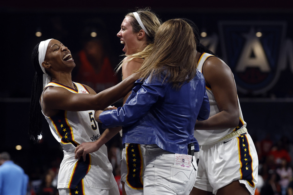 Indiana Fever guard Shey Peddy (5), guard Lexie Hull, center left, and head coach Stephanie White, center right, celebrate after a score to take the lead over the Atlanta Dream during the second half of Game 3 in the first round of the WNBA basketball playoffs, Thursday, Sept. 18, 2025, in Atlanta. (AP Photo/Butch Dill)
