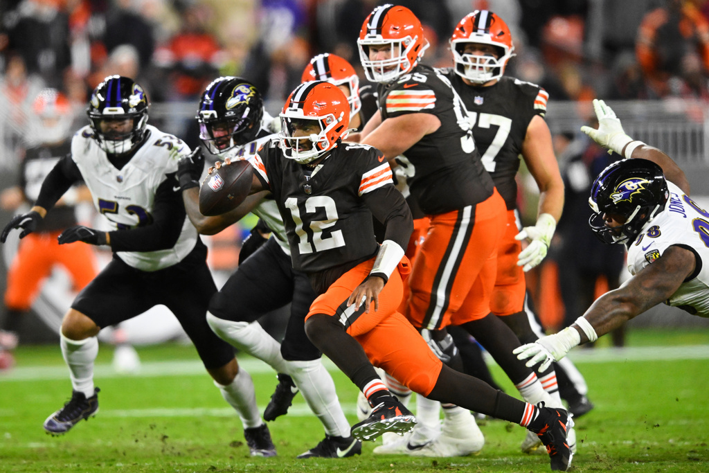 Cleveland Browns quarterback Shedeur Sanders (12) runs the ball as Baltimore Ravens defensive tackle Travis Jones, right, attempts to make the stop in the second half of an NFL football game in Cleveland, Sunday, Nov. 16, 2025. (AP Photo/David Richard)