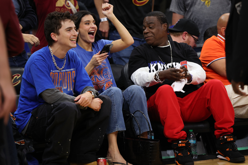 Timothée Chalamet, left, Kylie Jenner, center, and Tracy Morgan watch the second half of Game 4 in the Eastern Conference finals NBA basketball playoffs series between the New York Knicks and the Cleveland Cavaliers in Cleveland, Monday, May 25, 2026. (AP Photo/Tim Phillis)