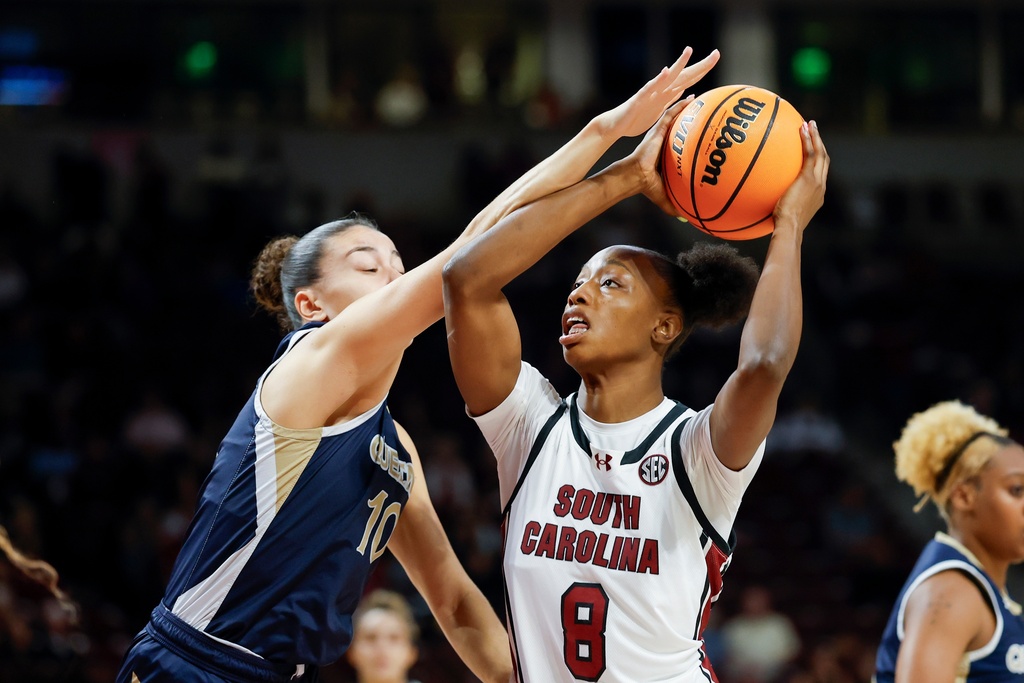 South Carolina forward Joyce Edwards (8) looks to shoot against Queens of Charlotte guard Ana Barreto, left, during the first half of an NCAA college basketball game in Columbia, S.C., Sunday, Nov. 23, 2025. (AP Photo/Nell Redmond)