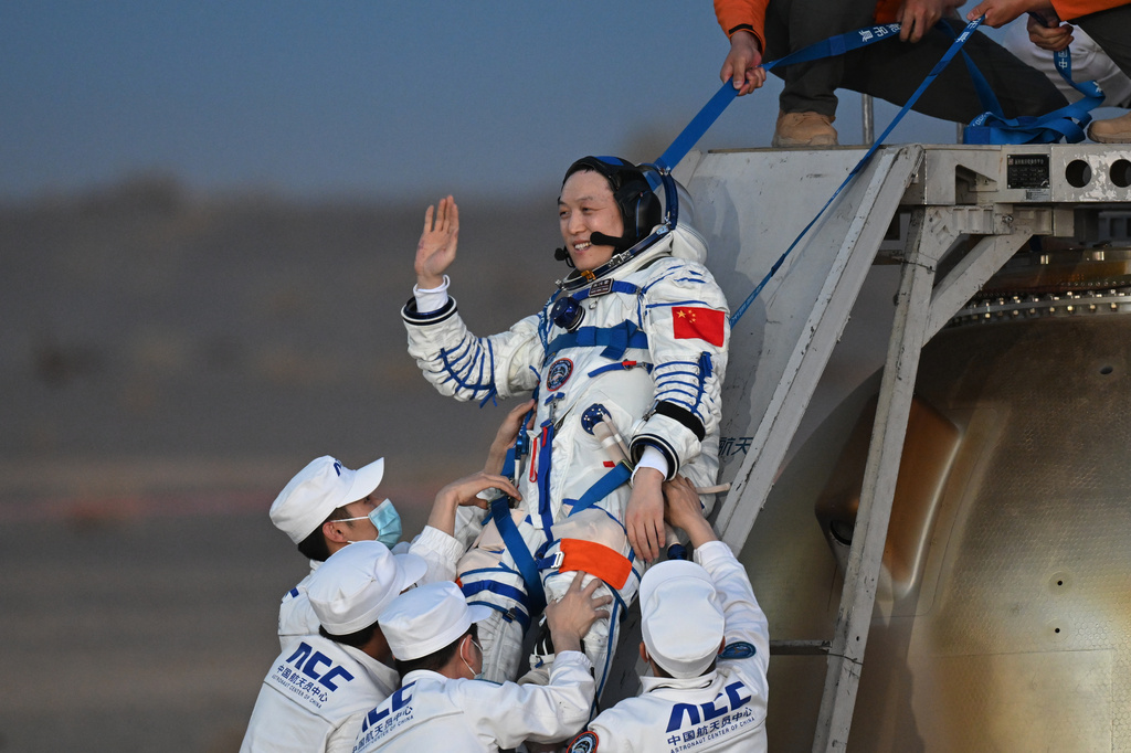 In this photo released by Xinhua News Agency, astronaut Zhang Hongzhang waves as he is carried out of the re-entry capsule after it landed successfully at the Dongfeng landing site in northern China's Inner Mongolia Autonomous Region on Friday, May 29, 2026. (Lian Zhen/Xinhua via AP)