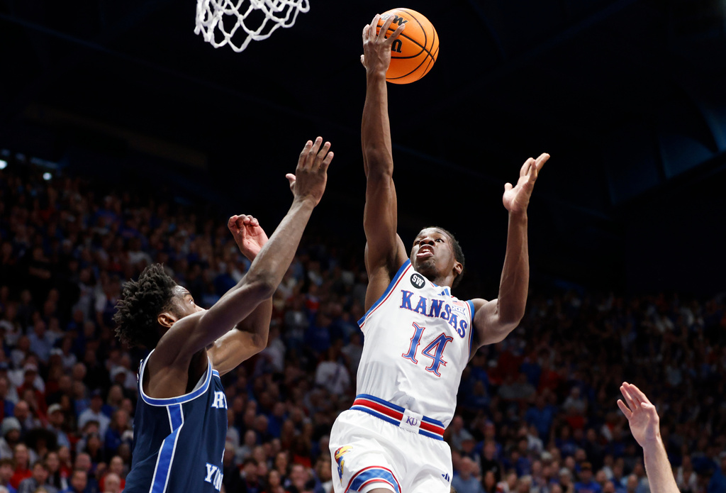 Kansas guard Melvin Council Jr. (14) goes yup to score as BYU forward AJ Dybantsa, left, defends during the first half of an NCAA college basketball game, Saturday, Jan. 31, 2026, in Lawrence, Kan. (AP Photo/Colin E. Braley)