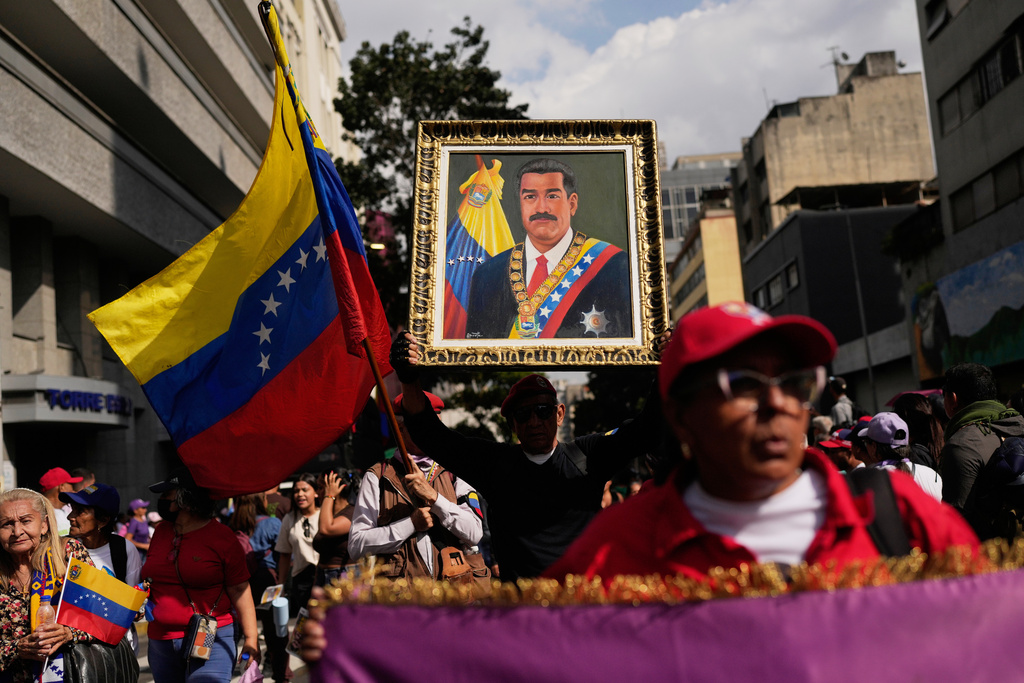 FILE - A government supporter holds an image of President Nicolas Maduro during a women's march to demand his return in Caracas, Venezuela, Jan. 6, 2026, three days after U.S. forces captured him and his wife. (AP Photo/Matias Delacroix, File)