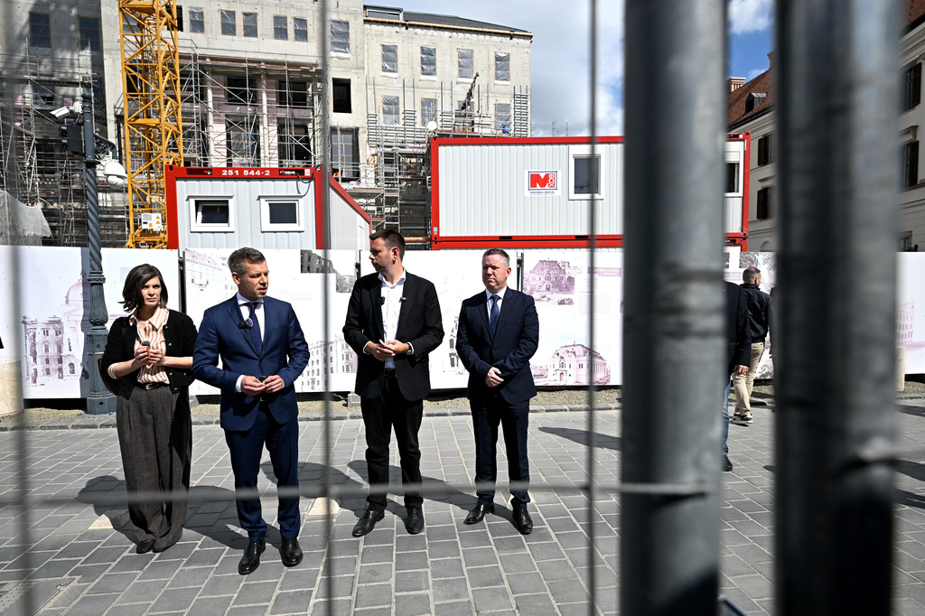 Hungary's Prime Minister Peter Magyar, second left, flanked by Minister of Transport and Innovation David Vitezy, second right, Minister of Interior Gabor Posfai, right, and Government Spokeswoman Vanda Szondi, attend the public dismantling of the barricade surrounding the former Karmelita Palace, which has previously housed the Prime Minister's Office, in the Castle District of Budapest, Hungary, Friday, May 15, 2026. (Robert Hegedus/MTI via AP)