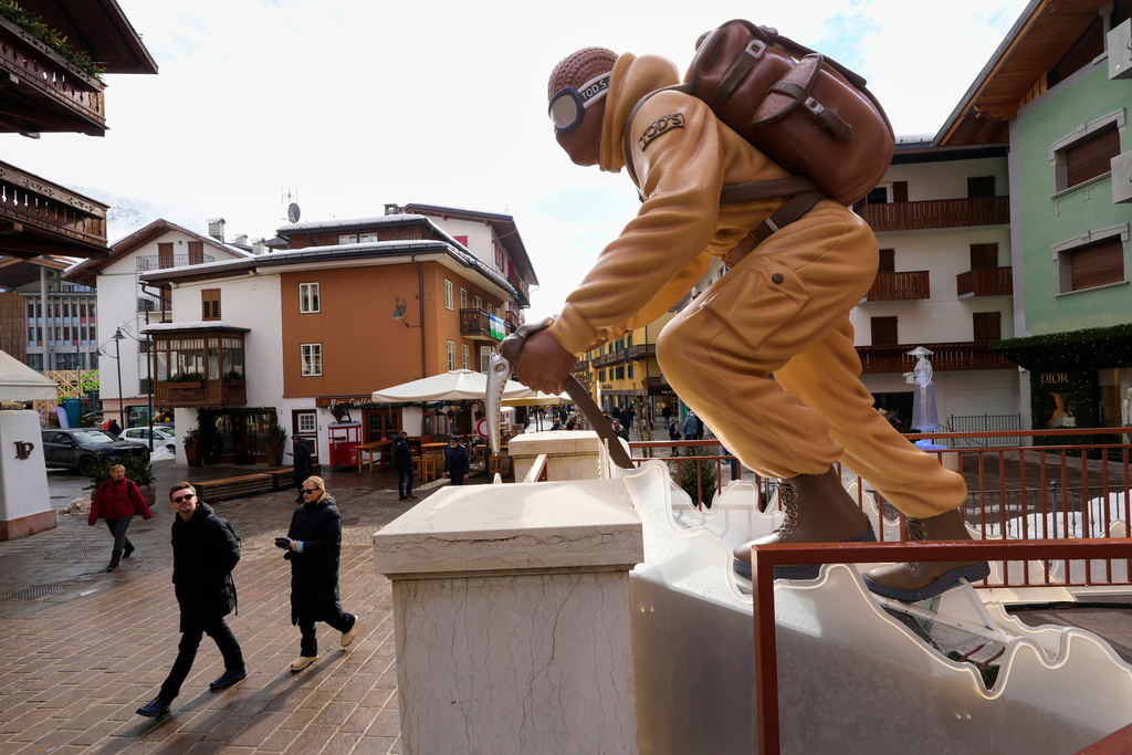 A mountaineer draws the attention of visitors outside a luxury retail shop at the 2026 Winter Olympics, in Cortina d'Ampezzo, Italy, Wednesday, Feb. 11, 2026. (AP Photo/Robert F. Bukaty)
