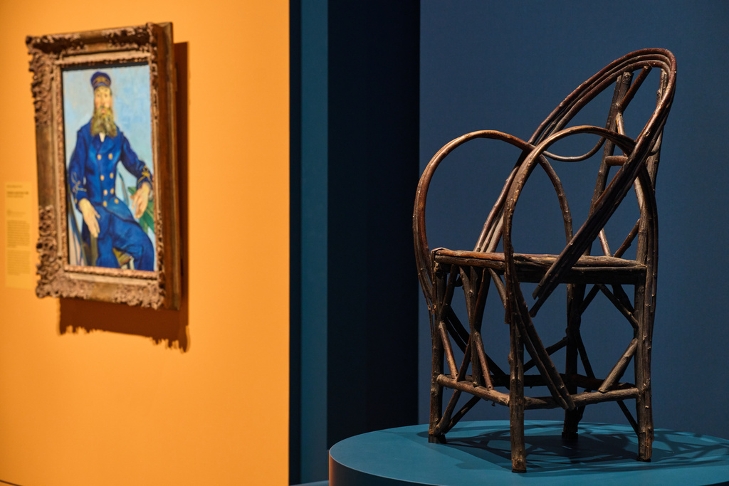 The chair in which bearded postman Joseph Roulin sat when he was portrayed by Vincent Van Gogh is displayed next to Roulin's portrait at the Van Gogh Museum in Amsterdam, Netherlands, Wednesday, Oct. 1, 2025. (AP Photo/Peter Dejong)
