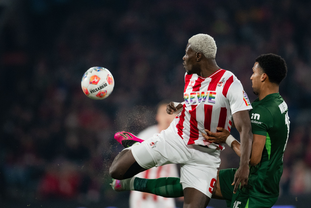 Cologne's Ragnar Ache, left, and Wolfsburg's Moritz Jenz battle for the ball during the German Bundesliga soccer match between 1. FC Cologne and VfL Wolfsburg in Cologne, Germany, Friday, Jan. 30, 2026. (Marius Becker/dpa via AP)