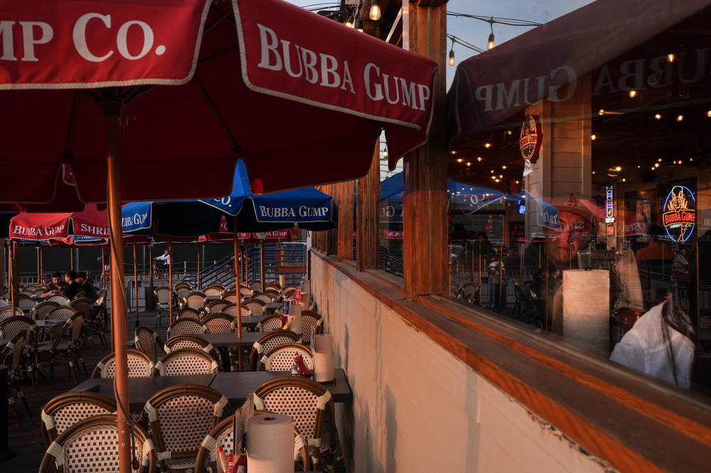 A diner looks out a restaurant window at sunset in Santa Monica, Calif., Wednesday, May 20, 2026. (AP Photo/Jae C. Hong)