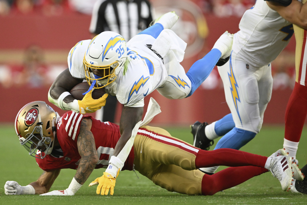 Los Angeles Chargers running back Raheim Sanders (35) jumps over San Francisco 49ers cornerback Chase Lucas during the second half of an NFL preseason football game in Santa Clara, Calif., Saturday, Aug. 23, 2025. (AP Photo/Eakin Howard)
