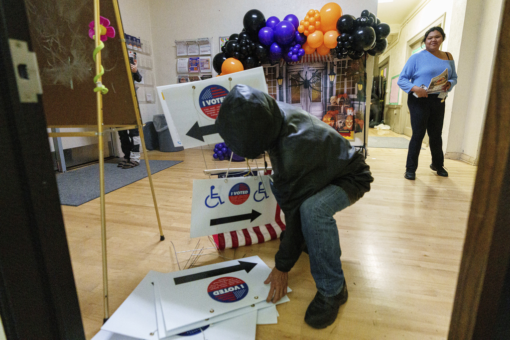 Election workers take down election signs as they close off the voting and drop off site at the Echo Park Recreation Center on Tuesday, Nov. 5, 2024, in Los Angeles. (AP Photo/Damian Dovarganes)