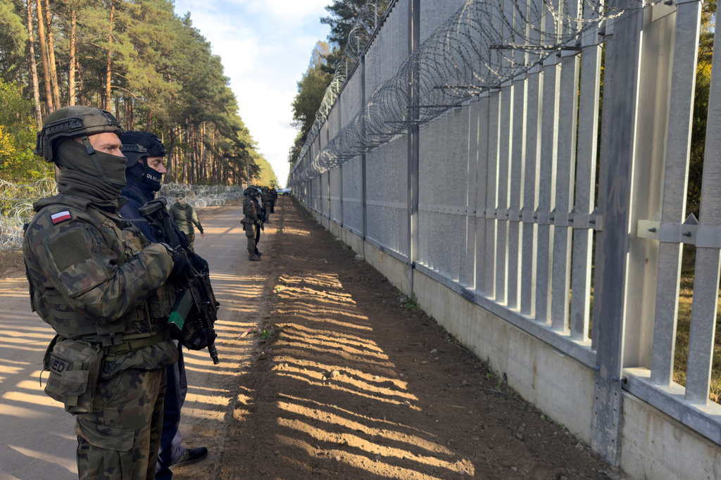FILE - Servicemen guard at a section of Poland - Belarus border barrier near the Polowce-Pieszczatka, Poland, Oct. 15, 2025. (AP Photo/Rafal Niedzielski, file)