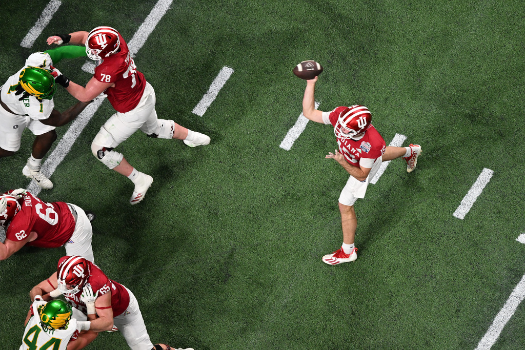 Indiana quarterback Fernando Mendoza (15) throws a touchdown pass against Oregon during the first half of the Peach Bowl NCAA college football playoff semifinal, Friday, Jan. 9, 2026, in Atlanta. (AP Photo/Danny Karnik)