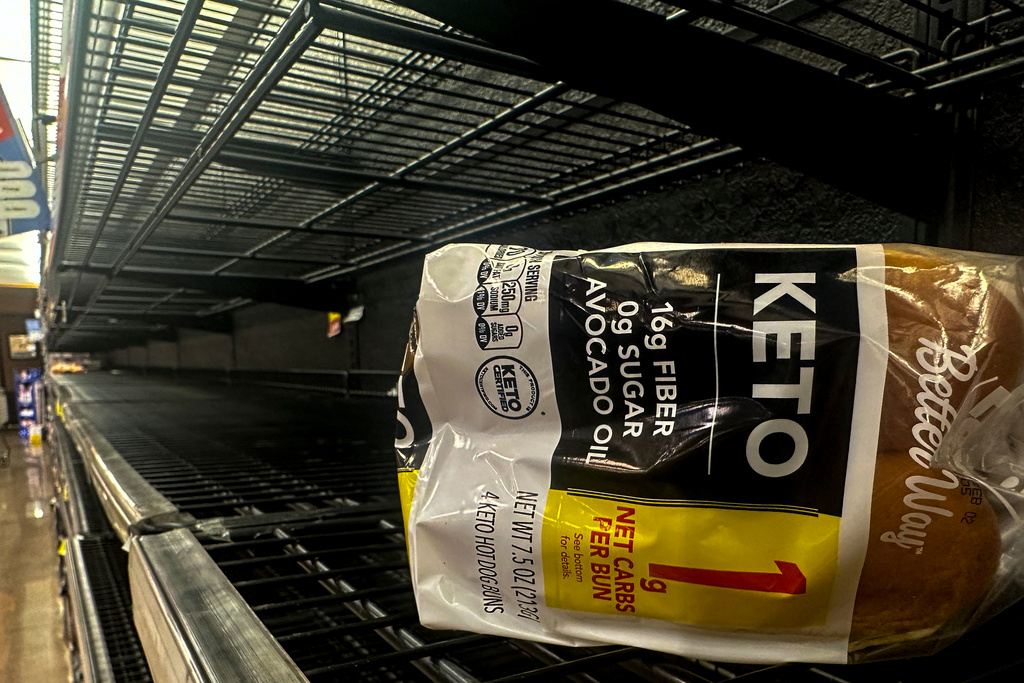 A loaf of bread sits on empty shelves in the bread isle in grocery store ahead of winter weather, Wednesday, Jan. 21, 2026, in Marietta, Ga. (AP Photo/Mike Stewart)