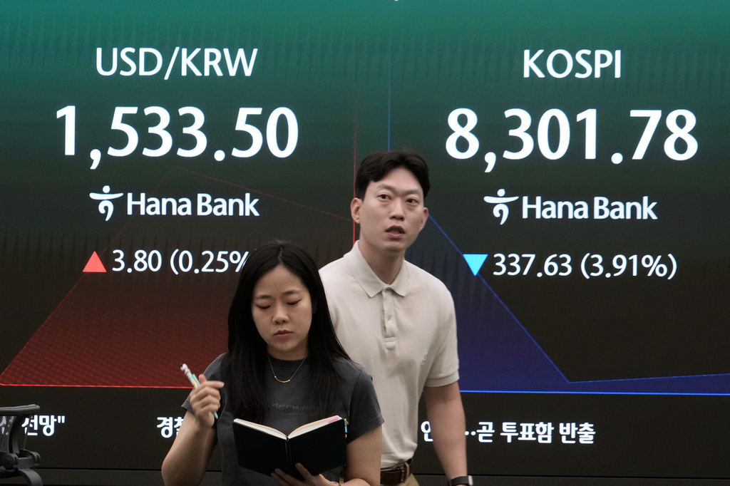 Currency traders pass by a screen showing the Korea Composite Stock Price Index (KOSPI) and the foreign exchange rate between U.S. dollar and South Korean won at the foreign exchange dealing room of the Hana Bank headquarters in Seoul, South Korea, Friday, June 5, 2026. (AP Photo/Ahn Young-joon)