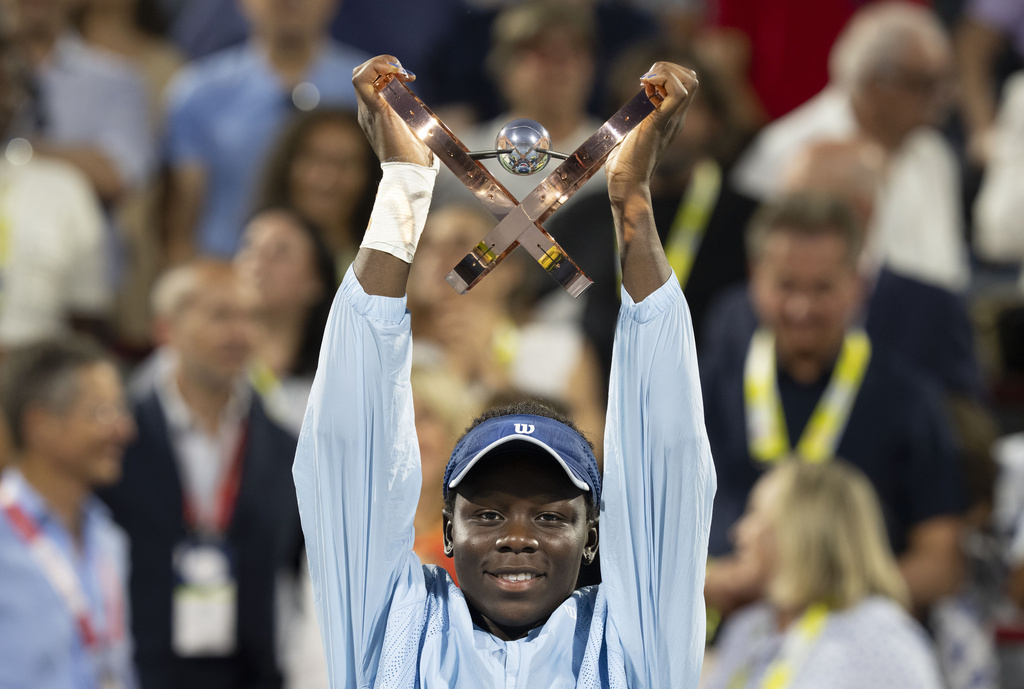 Victoria Mboko, of Canada, hoists the trophy following her win over Naomi Osaka, of Japan, in final action at the National Bank Open women's tennis tournament in Montreal, Thursday, Aug. 7, 2025. (Christinne Muschi/The Canadian Press via AP)