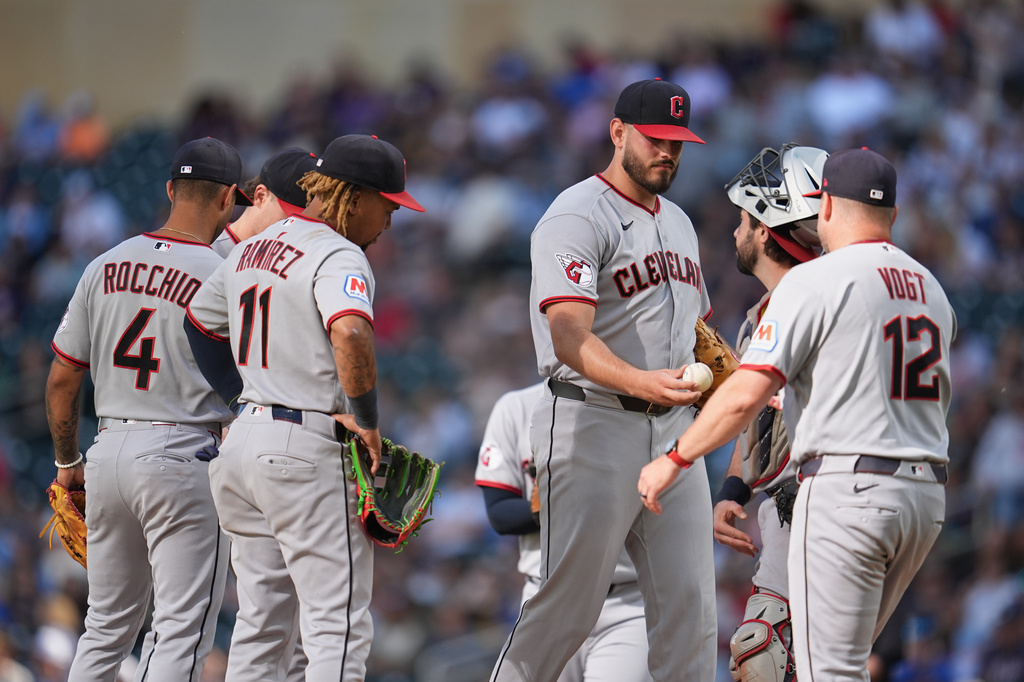 Cleveland Guardians relief pitcher Franco Aleman, middle, right, hands the game ball to manager Stephen Vogt (12) for a pitching change during the third inning of a baseball game against the Minnesota Twins Saturday, Sept. 12, 2026, in Minneapolis. (AP Photo/Abbie Parr)