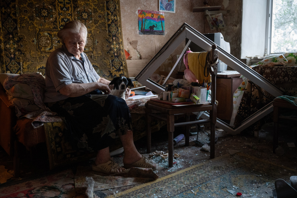 Elderly Liudmyla Tsapkova sits in her damaged apartment after the Russian missile attack in Kyiv, Ukraine, Thursday, July 2, 2026. (AP Photo/Danylo Antoniuk)