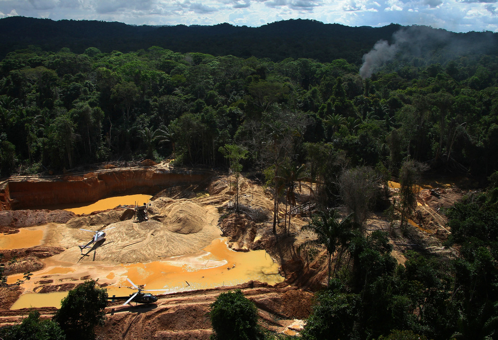 FILE - Helicopters are visible at an illegal mining camp during an operation by Brazil's environmental agency aimed at combating illegal mining in Yanomami Indigenous territory, Roraima state, Brazil, Feb. 11, 2023. (AP Photo/Edmar Barros, File)
