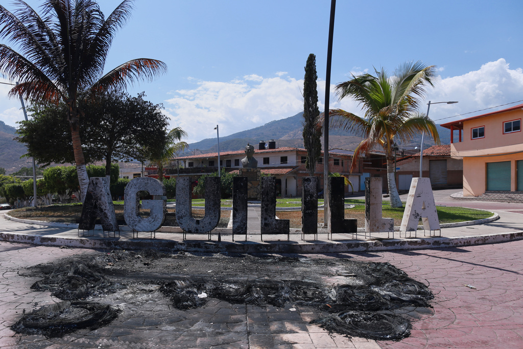 Letters spelling out the name of Aguililla, in Michoacan state, Mexico, stand burned, Tuesday, Feb. 24, 2026, after the Mexican army killed the leader of the Jalisco New Generation Cartel, Nemesio Oseguera Cervantes, known as "El Mencho." (AP Photo/Armando Solis)