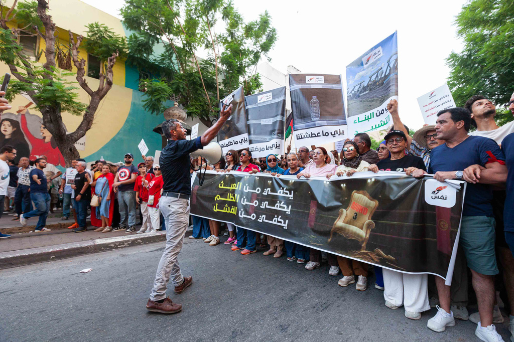People take part in a protest against rising prices, declining purchasing power and shortages of basic goods in Tunis, Tunisia, Thursday, Aug. 20, 2026. Banner in Arabic reads "Enough injustice, enough failure." (AP Photo/Ons Abid)