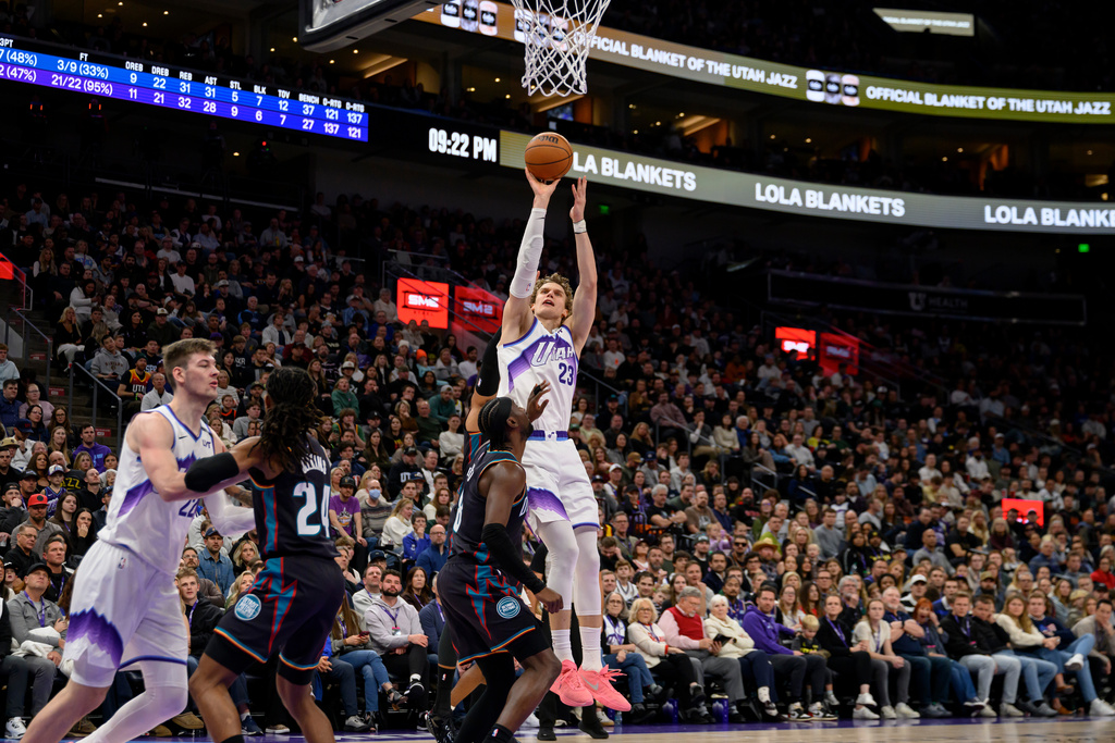 Utah Jazz forward Lauri Markkanen, right, shoots over Detroit Pistons guard Caris Levert, center right, during the second half of an NBA basketball game, Friday, Dec. 26, 2025, in Salt Lake City. (AP Photo/Tyler Tate)