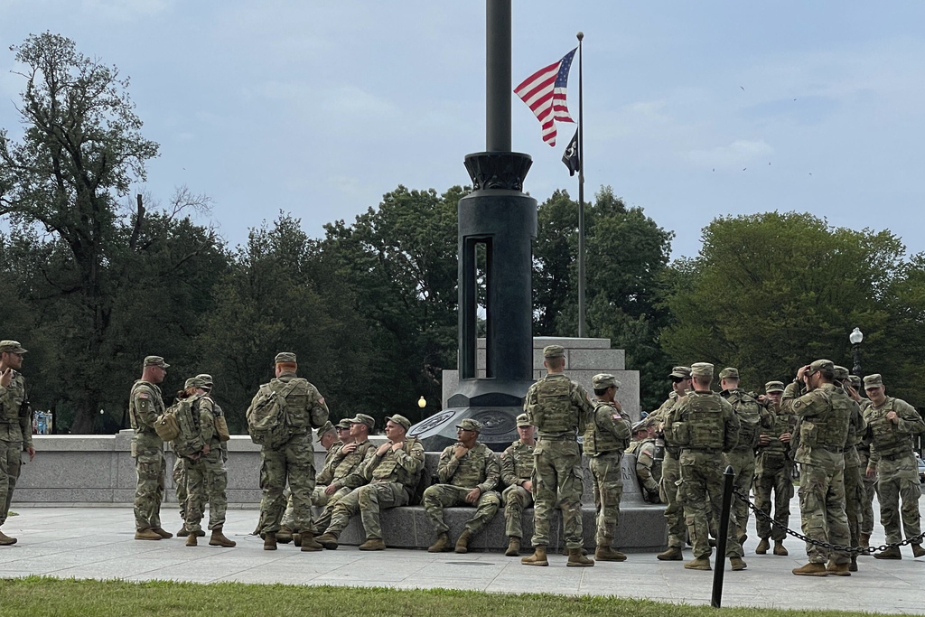 National Guard soldiers take a break at the World War II Memorial on the National Mall in Washington. Wednesday, Aug. 20, 2025. (AP Photo/Matthew Brown)