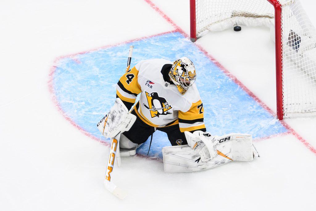 The puck goes past Pittsburgh Penguins goaltender Stuart Skinner (74) from a shot by Utah Mammoth right wing Dylan Guenther during the first period of an NHL hockey game Saturday, March 14, 2026, in Salt Lake City. (AP Photo/Tyler Tate)