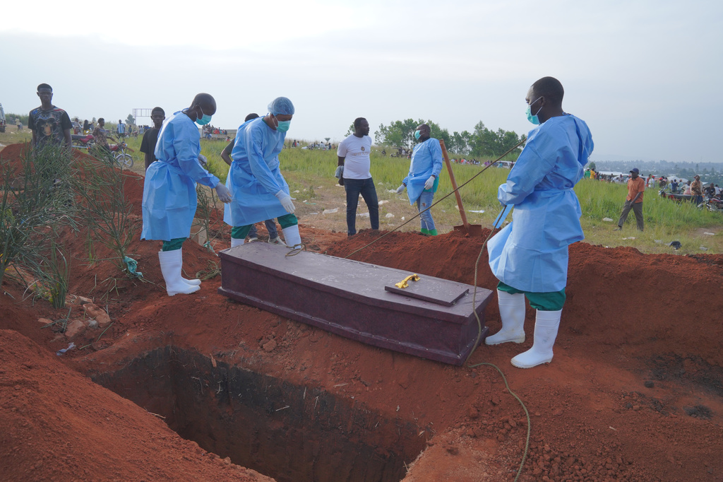 FILE - People dressed in protective gear prepare to lower into a grave the coffin containing the remains of six-year-old Baudjo Baraka Jules, who died of Ebola, in Bunia, Ituri province, eastern Congo, on Aug. 18, 2026. (AP Photo/Dieudonne Dirole, File)