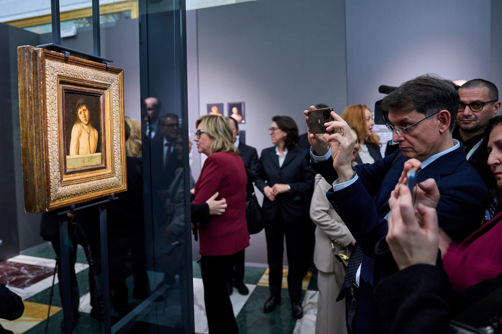 Journalists look at Antonello da Messina's Ecce Homo, a tempera-on-panel painting dating from around 1470 and measuring 20.3 by 14.9 centimeters, recently acquired by the Italian General Directorate of Museums for $14.9 million, or about 12.6 million euros in Rome, Thursday, March 26, 2026 . (AP Photo/Domenico Stinellis)