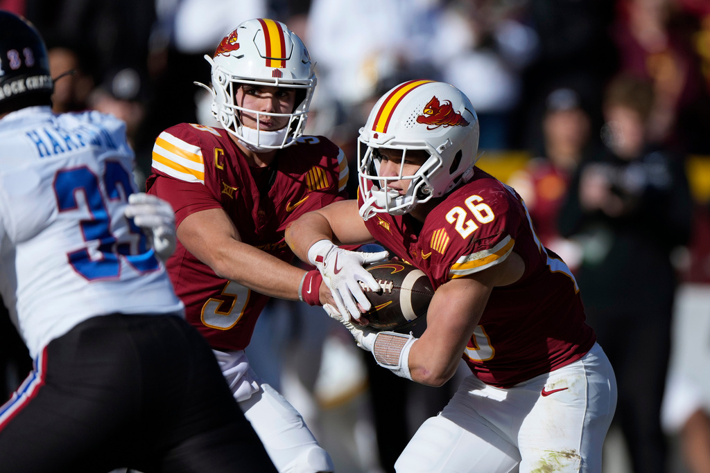 Iowa State quarterback Rocco Becht (3) hands off to running back Carson Hansen (26) during the first half of an NCAA college football game against Kansas, Saturday, Nov. 22, 2025, in Ames, Iowa. (AP Photo/Matthew Putney)