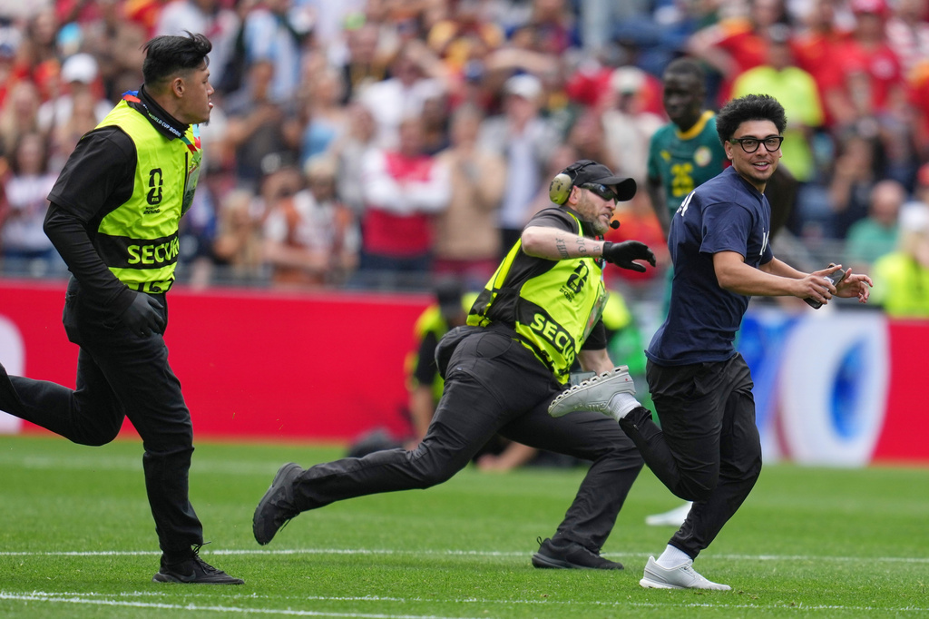 A fan runs onto the pitch during the World Cup round of 32 soccer match between Belgium and Senegal in Seattle, Wednesday, July 1, 2026. (AP Photo/Abbie Parr)