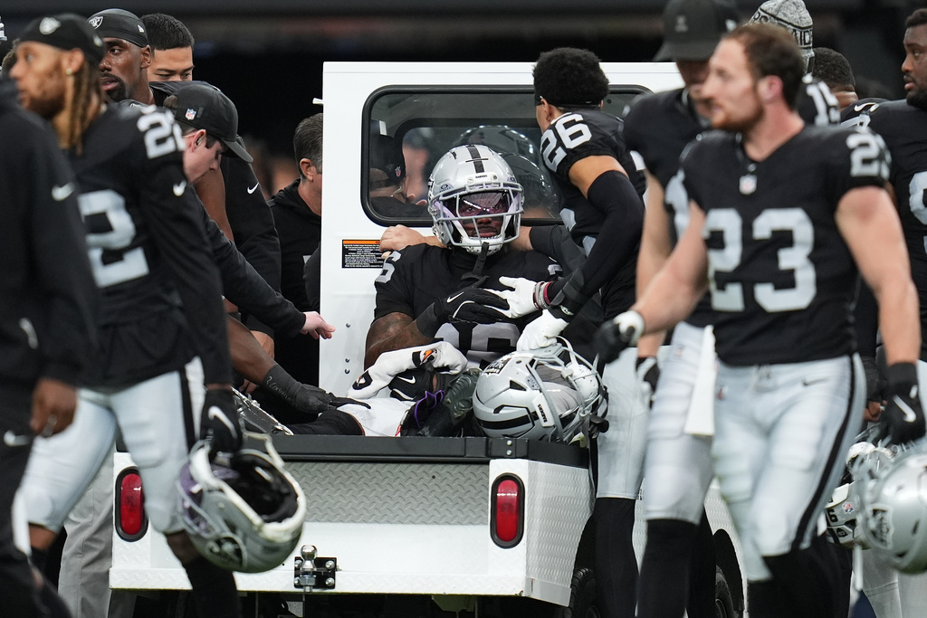 Las Vegas Raiders cornerback Kyu Blu Kelly, middle, is carted off the field during the first half of an NFL football game against the Denver Broncos in Las Vegas, Sunday, Dec. 7, 2025. (AP Photo/Gregory Bull)