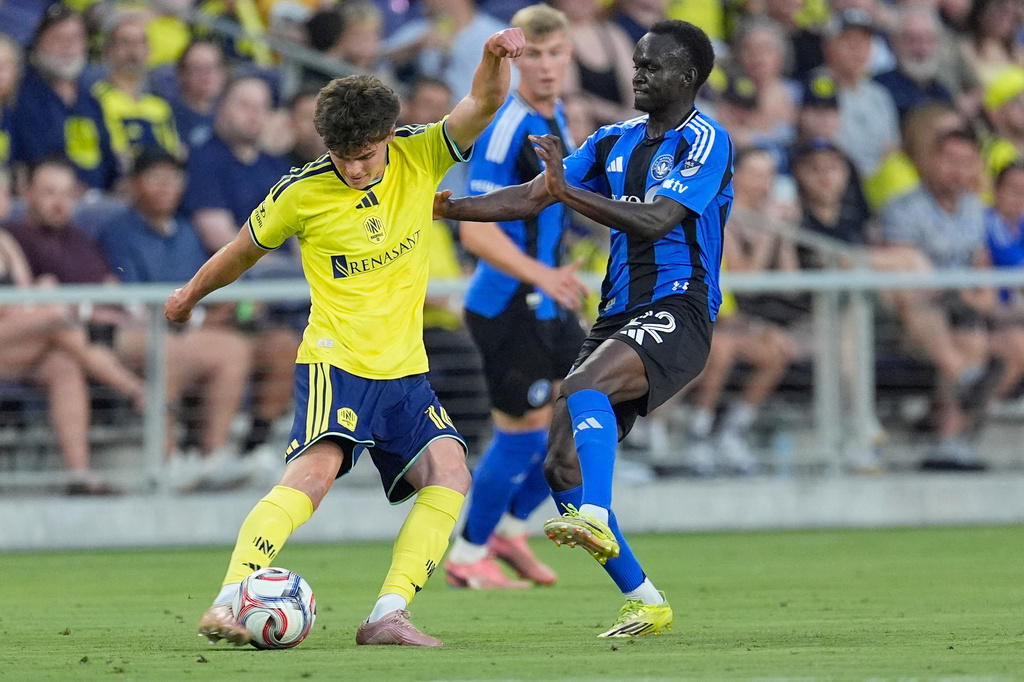 Nashville SC midfielder Matthew Corcoran, left, kicks the ball past CF Montréal midfielder Victor Loturi, right, during the first half of an MLS soccer match Wednesday, July 22, 2026, in Nashville, Tenn. (AP Photo/George Walker IV)