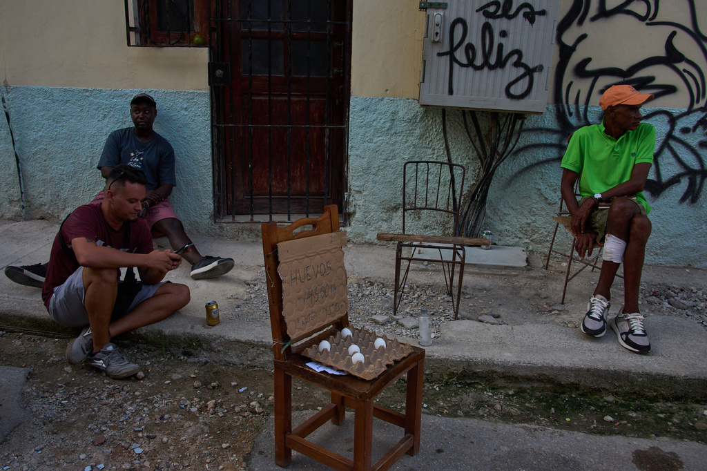 People hang out near eggs for sale on a street during a blackout in Havana, Cuba, Friday, Sept. 18, 2026. (AP Photo/Ramon Espinosa)