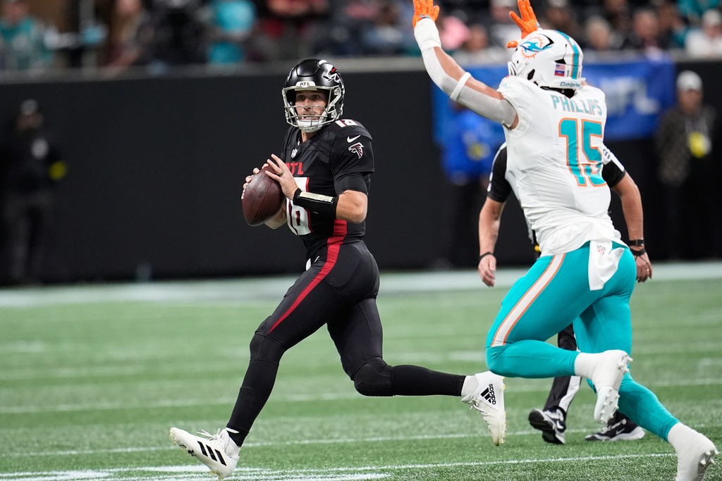 Atlanta Falcons quarterback Kirk Cousins (18) looks to pass as Miami Dolphins linebacker Jaelan Phillips (15) defends during the first half of an NFL football game Sunday, Oct. 26, 2025, in Atlanta. (AP Photo/Mike Stewart)