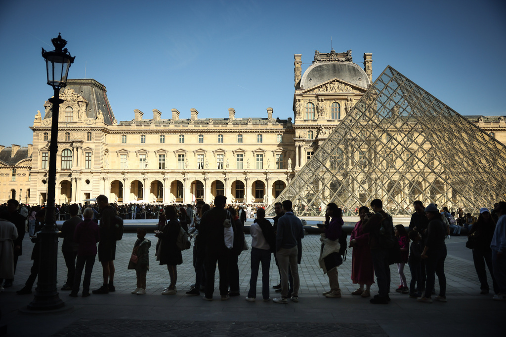 People queue to enter the Louvre museum in Paris, Wednesday Feb. 25, 2026. (AP Photo/Thomas Padilla)