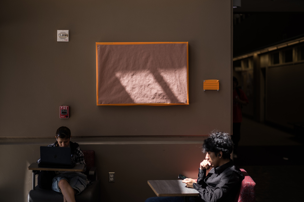 Students sit near a covered painting of Cesar Chavez at the Santa Ana College in Santa Ana, Calif., Thursday, March 19, 2026. (AP Photo/Jae C. Hong)