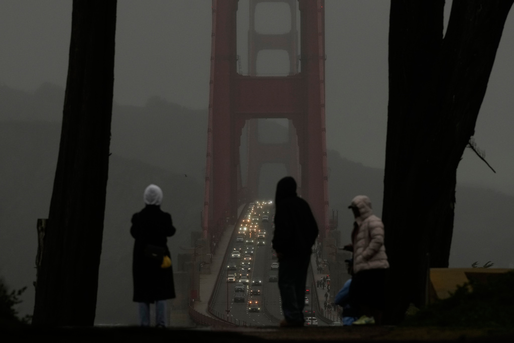 People look toward traffic on the Golden Gate Bridge from the Golden Gate Overlook in San Francisco, Tuesday, Dec. 23, 2025. (AP Photo/Jeff Chiu)
