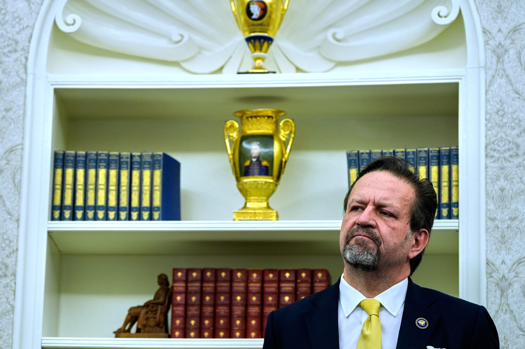 FILE - Sebastian Gorka listens as President Donald Trump speaks with reporters after signing executive orders in the Oval Office of the White House, April 23, 2025, in Washington. (AP Photo/Alex Brandon, File)