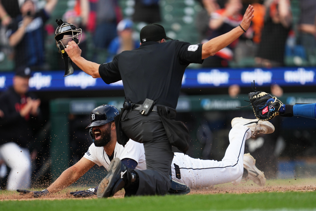 Detroit Tigers' Riley Greene slides safely into home plate past the tag of Kansas City Royals catcher Carter Jensen during the ninth inning of a baseball game Thursday, April 16, 2026, in Detroit. (AP Photo/Paul Sancya)
