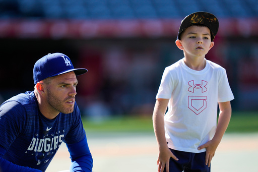 FILE - Los Angeles Dodgers first baseman Freddie Freeman (5) and his son, Charlie Freeman, participate in batting practice before a baseball game against the Los Angeles Angels in Anaheim, Calif., June 21, 2023. (AP Photo/Ashley Landis, File) FILE - Los Angeles Dodgers first baseman Freddie Freeman (5) and his son, Charlie Freeman, participate in batting practice before a baseball game against the Los Angeles Angels in Anaheim, Calif., June 21, 2023. (AP Photo/Ashley Landis, File)