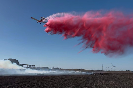 This image provided by Texas A&M Forest Service shows an aircraft contracted by Texas A&M Forest Service dropping fire retardant on the Mill Fire in Gregory, Texas, Wednesday, Oct. 29, 2025. (Texas A&M Forest Service via AP) This image provided by Texas A&M Forest Service shows an aircraft contracted by Texas A&M Forest Service dropping fire retardant on the Mill Fire in Gregory, Texas, Wednesday, Oct. 29, 2025. (Texas A&M Forest Service via AP)