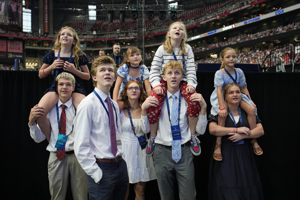 People watch as a band performs before the start of a memorial for conservative activist Charlie Kirk, Sunday, Sept. 21, 2025, at State Farm Stadium in Glendale, Ariz. (AP Photo/John Locher)
