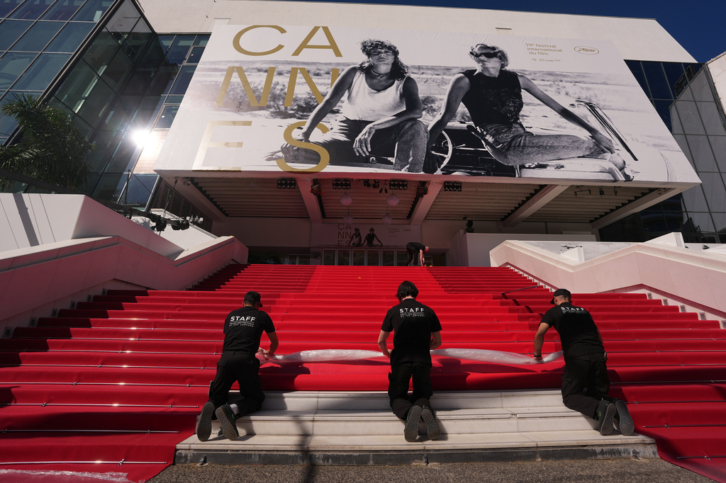 Crew members install the red carpet at the Palais des Festivals ahead of the opening ceremony of the 79th international film festival, Cannes, southern France, Tuesday, May 12, 2026. (AP Photo/Andreea Alexandru)