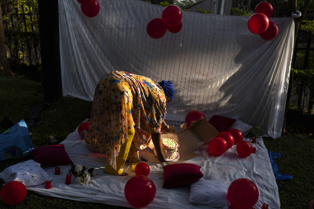 Fathiya Natukunda places a cake at a picnic to celebrate a friend's birthday in a park, Sunday, Nov. 24, 2024, in Kampala, Uganda. (AP Photo/David Goldman)
