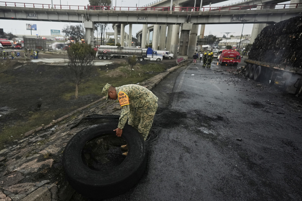 A soldier removes a burned tire from the scene of a gas tanker explosion in Mexico City, Wednesday, Sept. 10, 2025. (AP Photo/Fernando Llano)